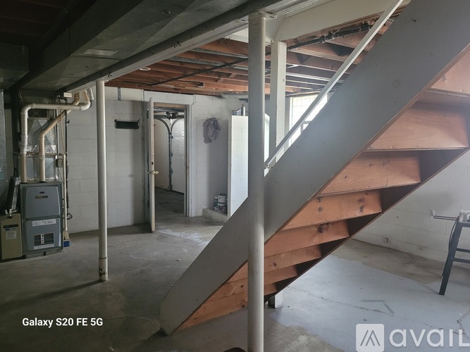 A staircase in a building with a metal railing and wooden steps.