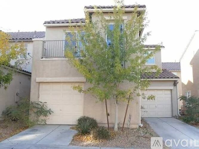 A house with a balcony and a tree in front.