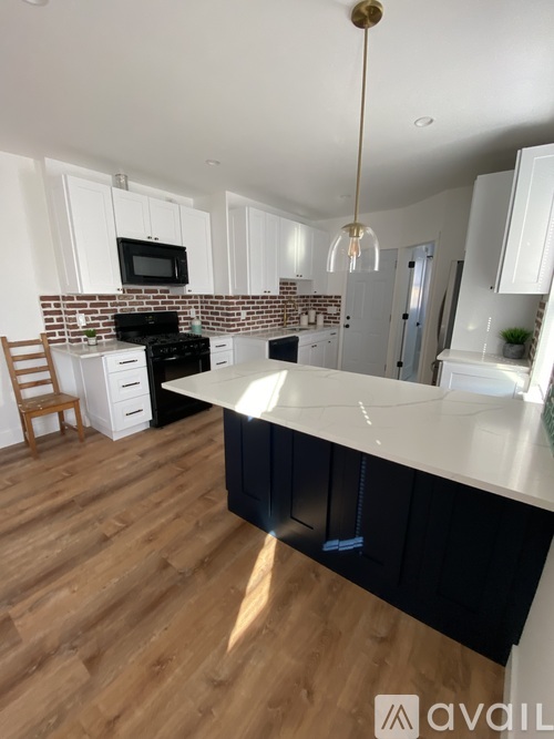 A kitchen with black cabinets and a white countertop.