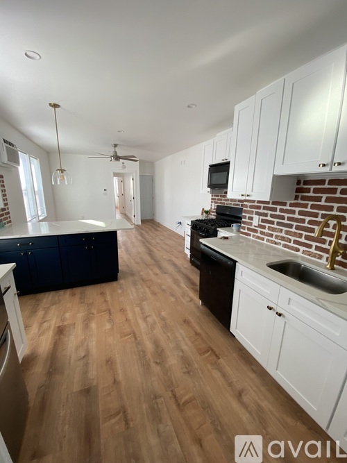 A kitchen with wooden floors and white cabinets.