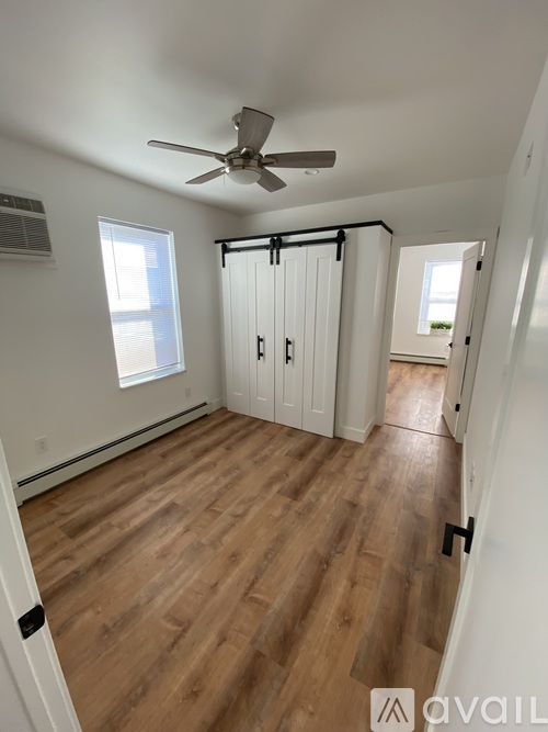 A room with a ceiling fan and sliding doors.