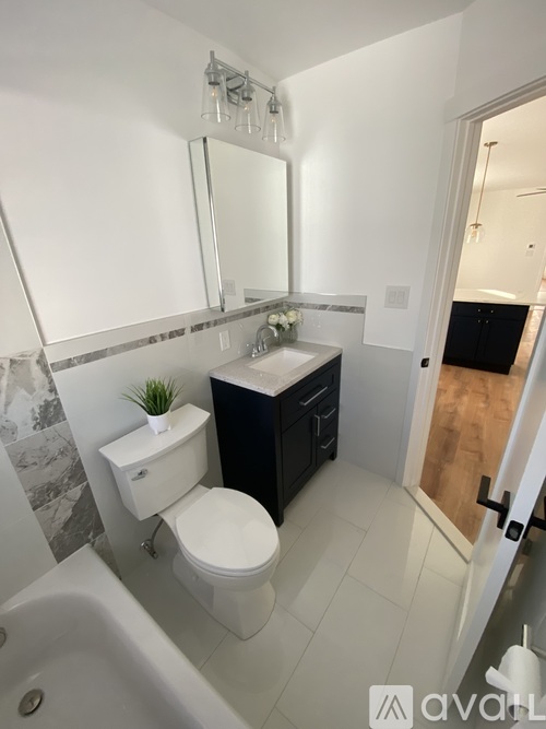 A white toilet sits in a bathroom next to a sink.
