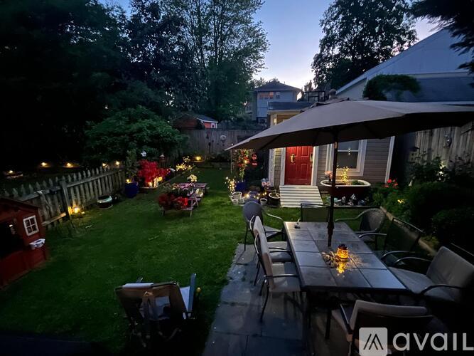 A backyard with a table and chairs under a canopy.