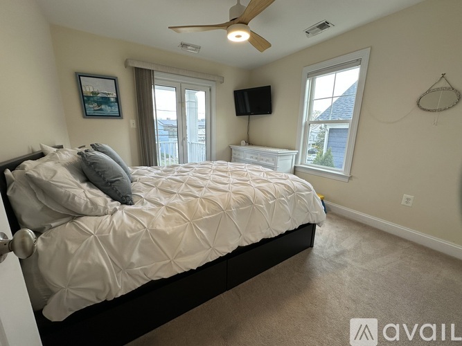 A bedroom with a large bed and a ceiling fan.