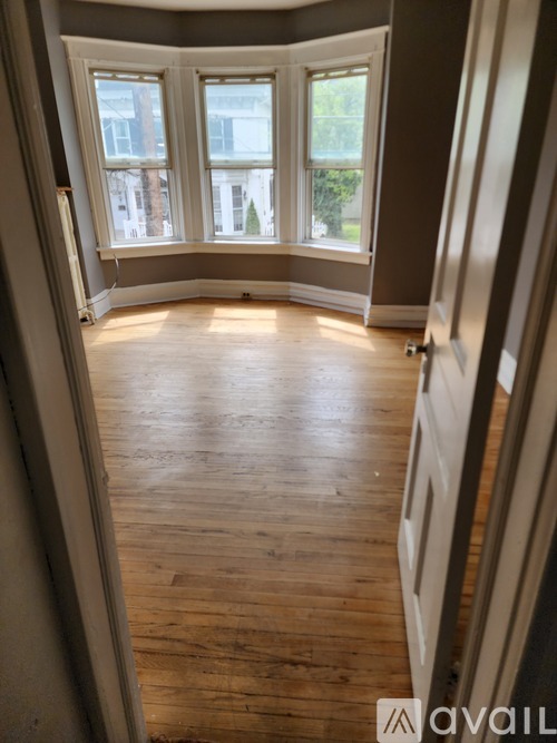 A room with wooden floors and a large window.