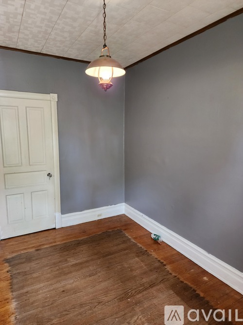 A room with a wooden floor and a white door.