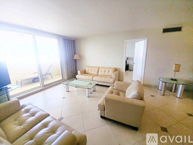 A living room with a white couch and a brown leather chair.