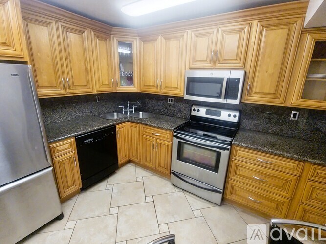 A kitchen with wooden cabinets and black appliances.