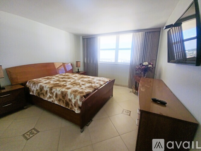 A bedroom with a large bed and a brown desk.