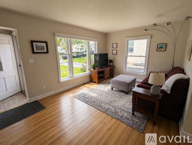 A living room with a couch, a television, and a window.