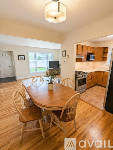 A dining room with a wooden table and chairs.