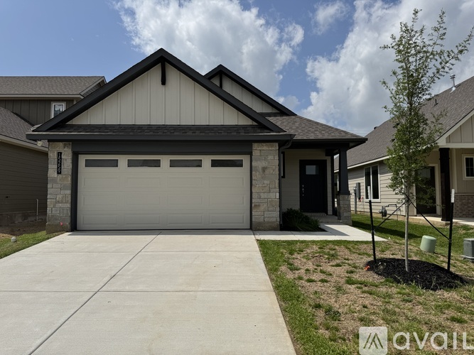 A house with a garage and a driveway in front.