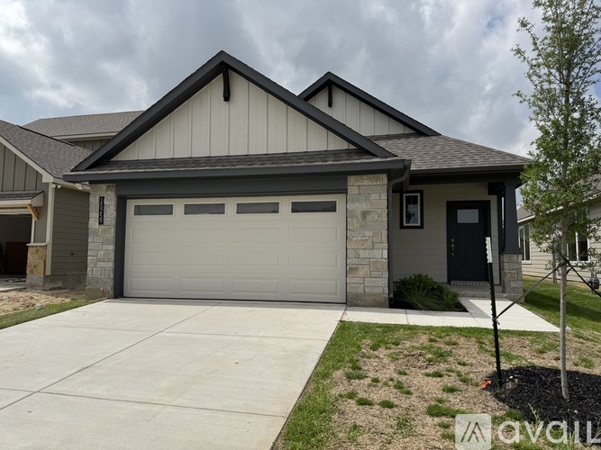 A house with a grey garage door and a brown roof.