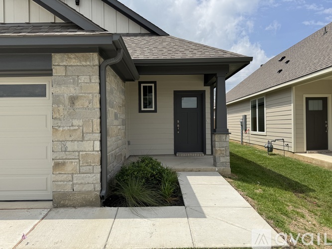 A house with a grey garage door and a black front door.