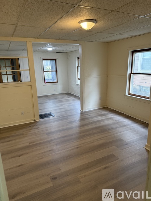 A room with wooden flooring and a window.