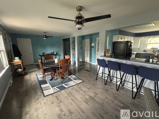A dining room with a wooden table and chairs.