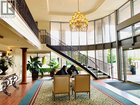 A large, well-lit atrium with a staircase and a chandelier.
