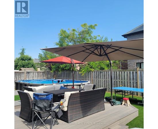A pool table with chairs and an umbrella in a backyard.
