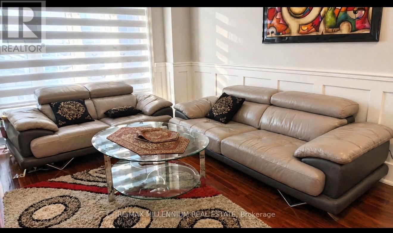 A living room with a glass coffee table and two grey couches.