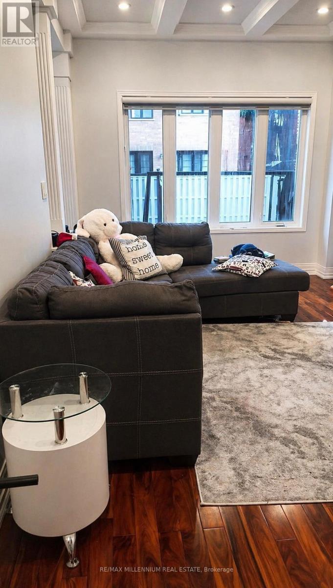 A living room with a grey couch and a white bear on it.