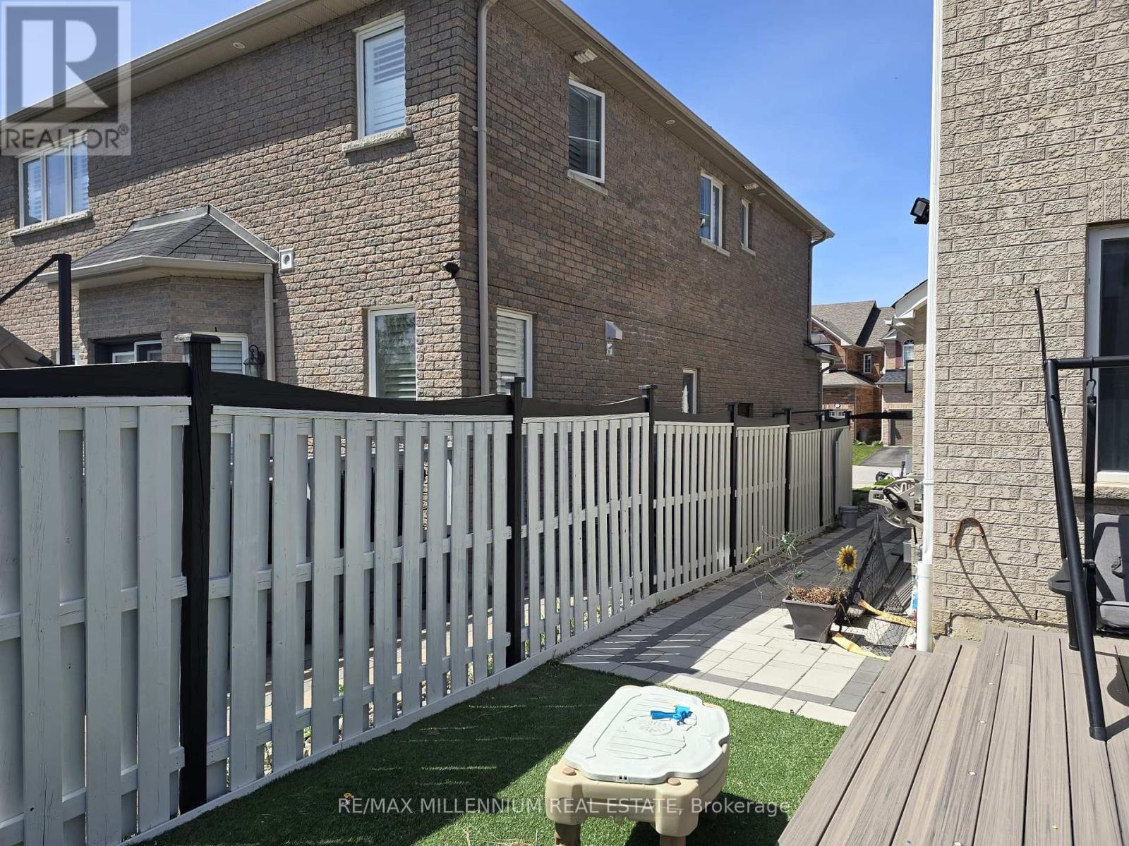 A house with a white picket fence and a hot tub in the yard.