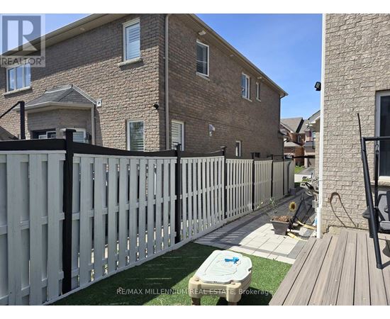 A house with a white picket fence and a hot tub in the yard.
