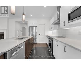 A modern kitchen with white cabinets and stainless steel appliances.