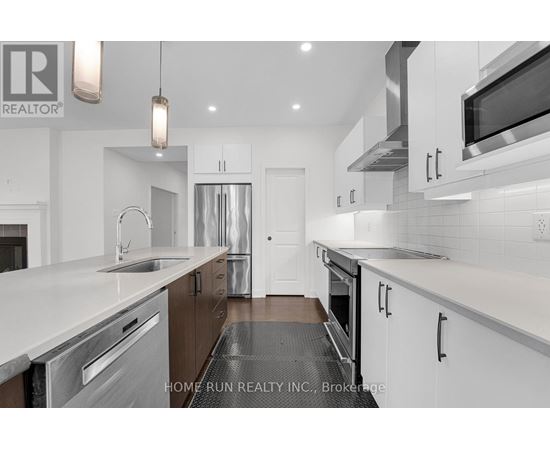 A modern kitchen with white cabinets and stainless steel appliances.