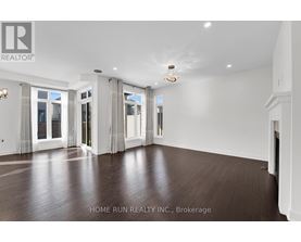 A spacious room with wooden floors and white walls.