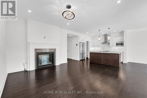 A spacious living room with a fireplace and a large painting on the wall.