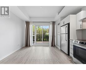 A kitchen with white appliances and a large window with curtains.