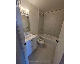 A white bathroom with a sink, toilet and bathtub.