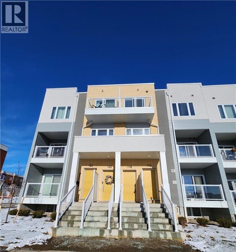 A modern apartment building with a clear blue sky in the background.