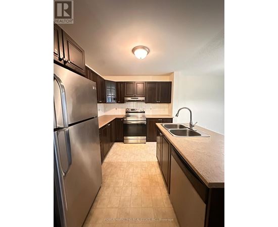 A kitchen with a stainless steel refrigerator and a sink.