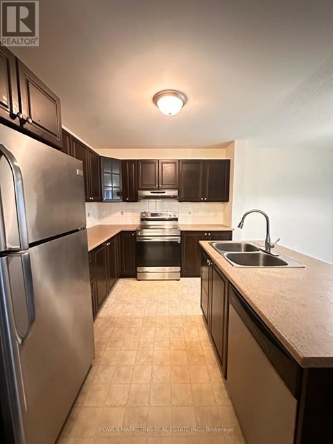 A kitchen with a stainless steel refrigerator and a sink.