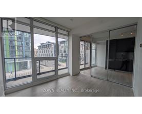 A room with a view of a street and buildings outside.