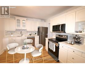 A kitchen with white cabinets and a black stove top oven.