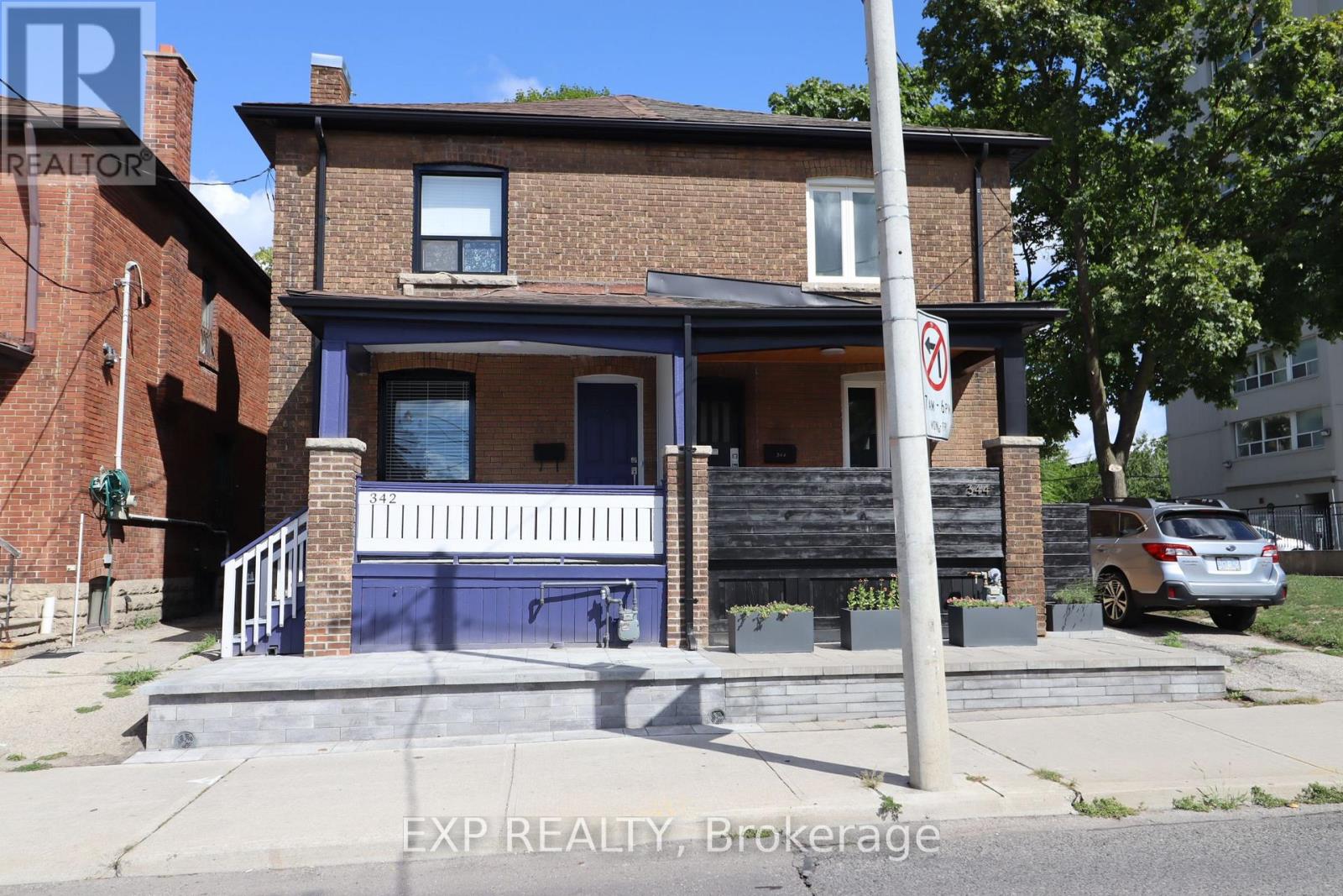 A house with a blue front door and a no parking sign on the street.