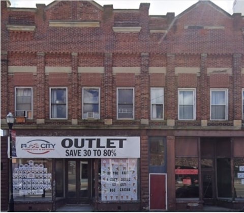A red brick building with a sign that says "RJCITY OUTLET SAVE 30 TO 80%".
