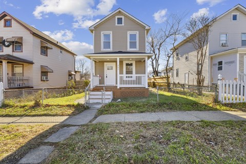 A house with a white picket fence in front of it.