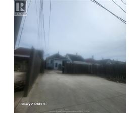 A realtor's photo of a residential area with houses and a fence.