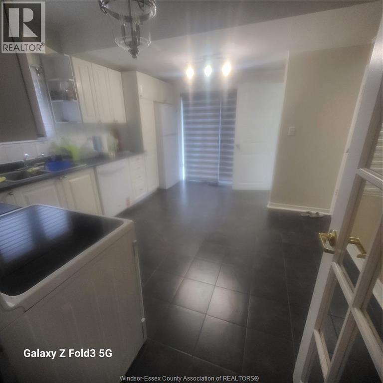 A kitchen with black tile flooring and white walls.
