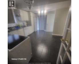 A kitchen with black tile flooring and white walls.