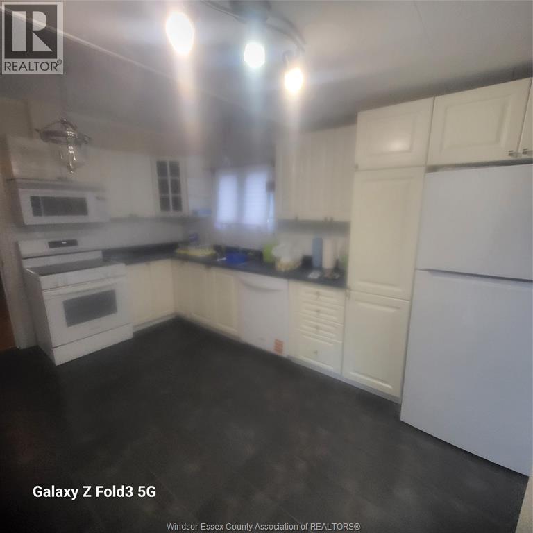 A kitchen with white cabinets and appliances.