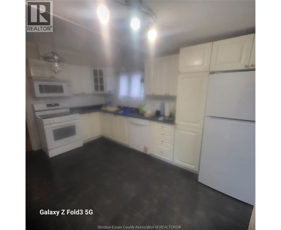 A kitchen with white cabinets and appliances.