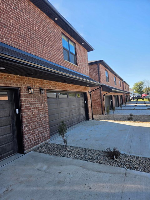 A row of houses with garages and driveways.