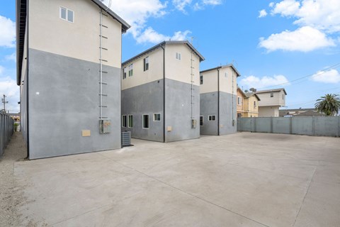 A concrete parking lot with a building in the background.