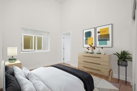 A bedroom with a bed, nightstand, and two framed pictures on the wall.