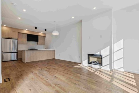 A modern living room with a fireplace and wooden flooring.