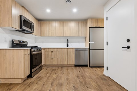 A kitchen with wooden cabinets and a white door.